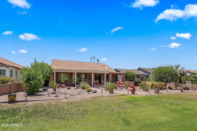 back of property with a yard and a patio