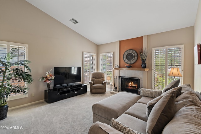 carpeted living room featuring a fireplace, high vaulted ceiling, and plenty of natural light