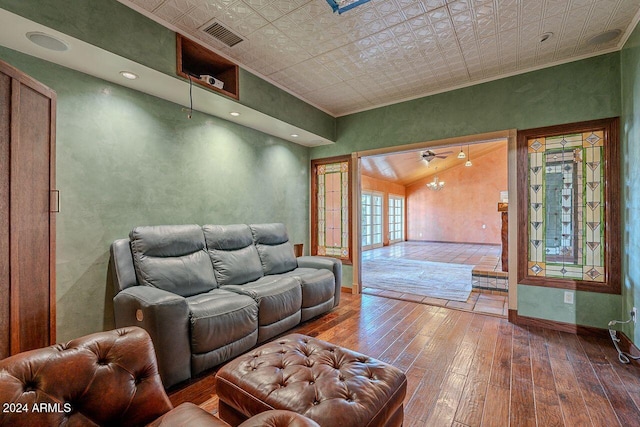 living room featuring lofted ceiling, french doors, hardwood / wood-style flooring, and crown molding