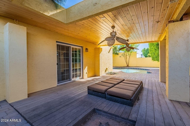 wooden terrace with ceiling fan and a fenced in pool