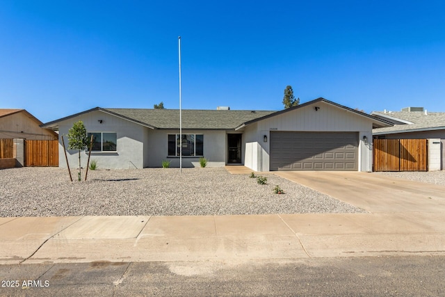 single story home with stucco siding, concrete driveway, an attached garage, a gate, and fence