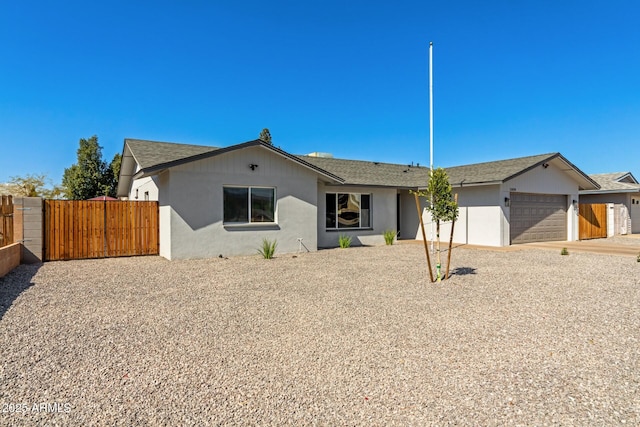 ranch-style home featuring a garage, fence, a gate, and stucco siding