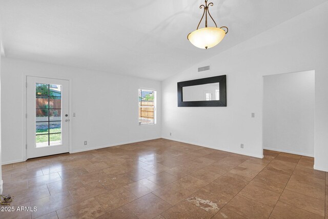 unfurnished room with visible vents, baseboards, a wealth of natural light, and vaulted ceiling
