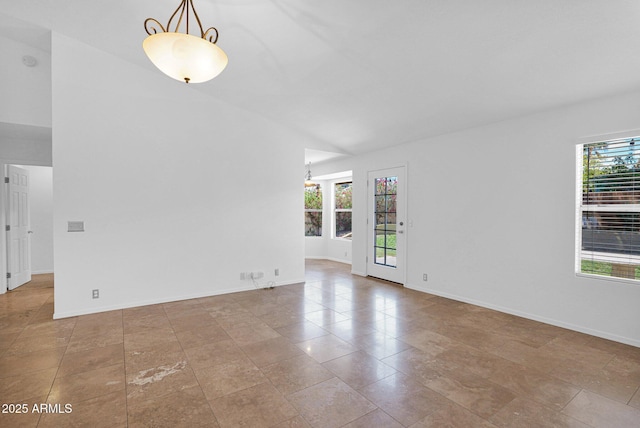 spare room with baseboards and a healthy amount of sunlight