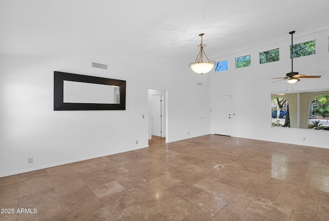 unfurnished living room featuring visible vents, baseboards, ceiling fan, and stone finish floor
