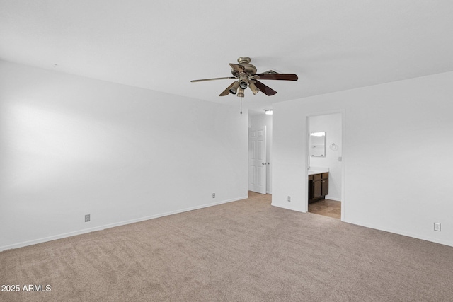 unfurnished bedroom with connected bathroom, a ceiling fan, baseboards, and light carpet