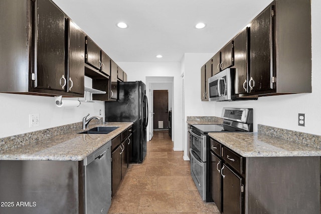 kitchen featuring recessed lighting, a sink, appliances with stainless steel finishes, and stone tile floors