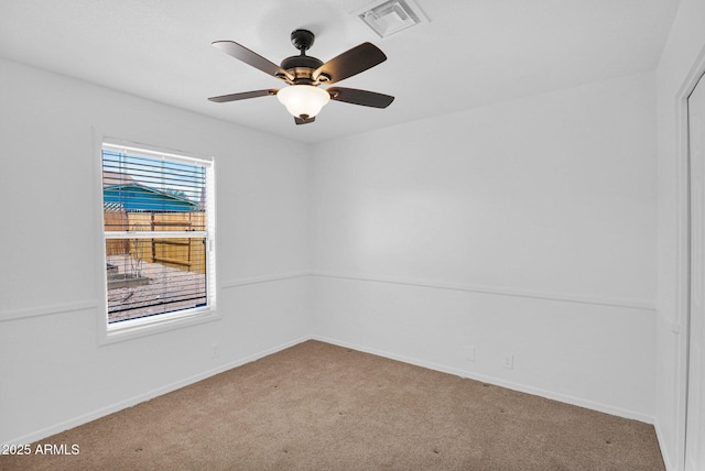 spare room with carpet floors, a ceiling fan, baseboards, and visible vents