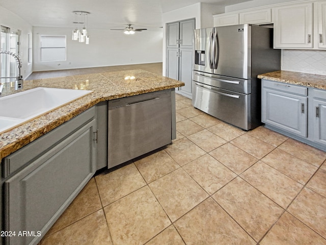 kitchen with stainless steel appliances, gray cabinets, ceiling fan, and sink