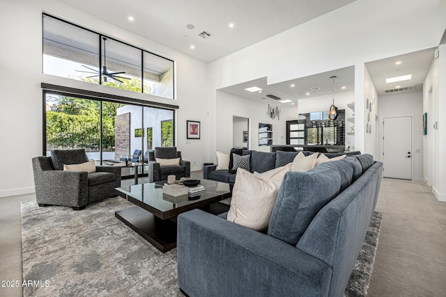 living room with concrete flooring and a towering ceiling