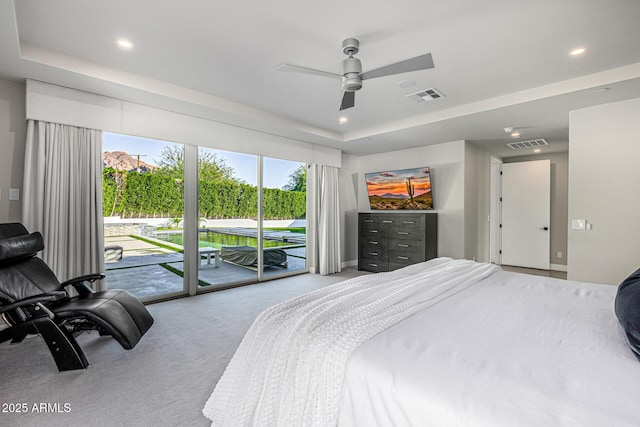 carpeted bedroom featuring a tray ceiling, access to outside, and ceiling fan