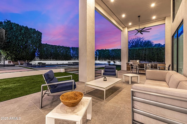 patio terrace at dusk featuring a pool, ceiling fan, and an outdoor hangout area