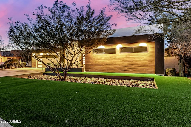 view of front of home with a garage and a lawn