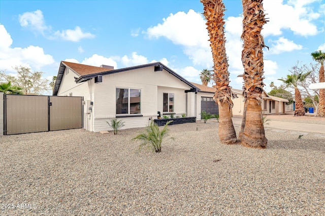 view of front of home with concrete driveway, a gate, and an attached garage