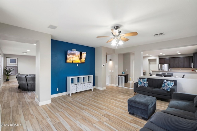 living room with ceiling fan and light wood-type flooring