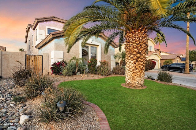 mediterranean / spanish-style house featuring a yard and a garage