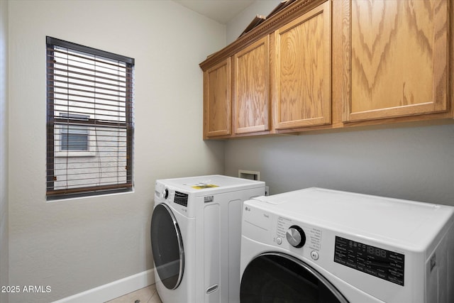 laundry area with washing machine and dryer and cabinets