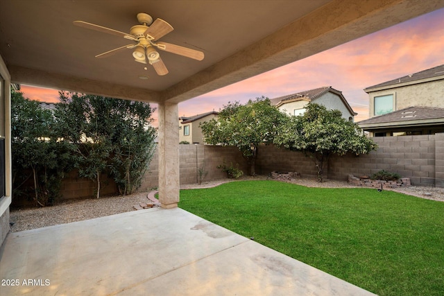 yard at dusk with a patio area and ceiling fan