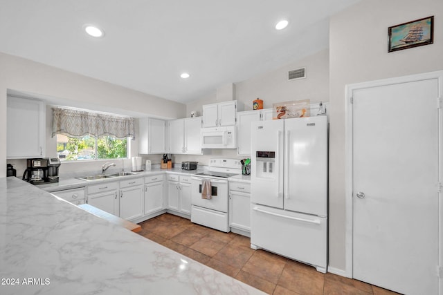 kitchen featuring light stone counters, white appliances, vaulted ceiling, sink, and white cabinets