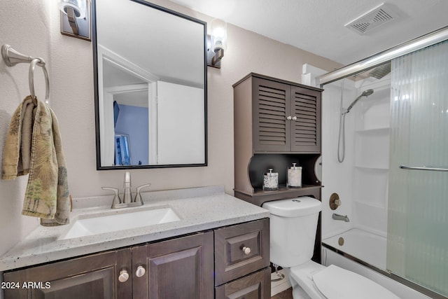 full bathroom featuring toilet, combined bath / shower with glass door, a textured ceiling, and vanity