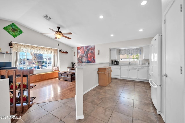 kitchen with ceiling fan, light hardwood / wood-style flooring, white appliances, vaulted ceiling, and white cabinets