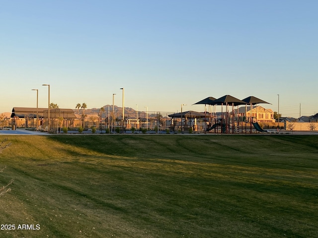 view of property's community with playground community and a yard