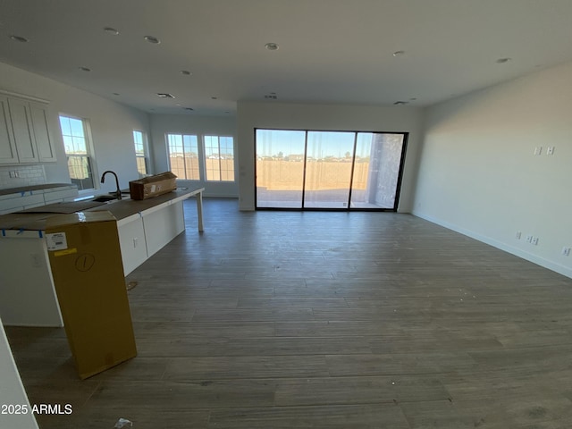 kitchen featuring a wealth of natural light, open floor plan, white cabinets, and wood finished floors