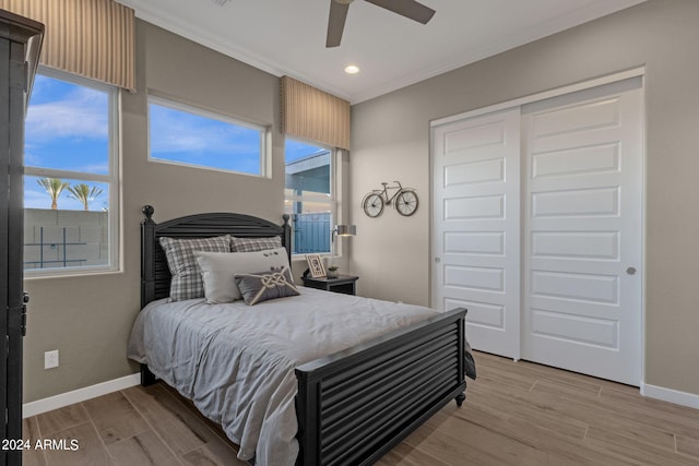 bedroom with baseboards, a closet, light wood-type flooring, and crown molding