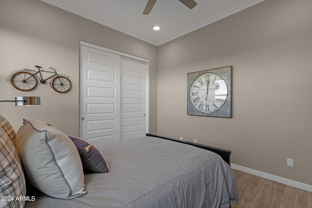 bedroom with baseboards, ornamental molding, wood finished floors, a closet, and recessed lighting