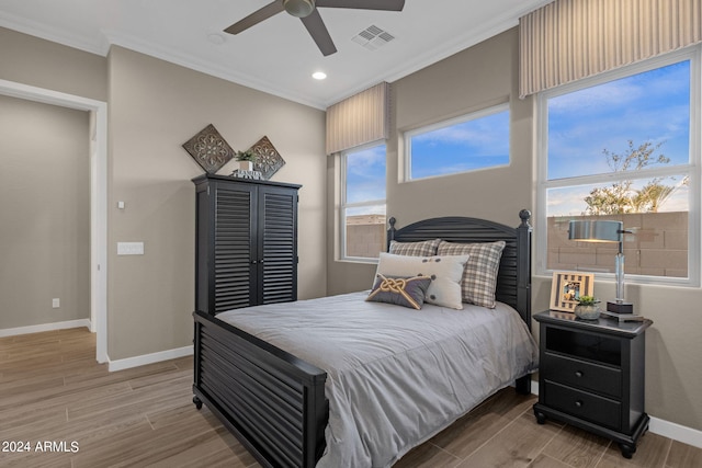 bedroom featuring baseboards, crown molding, visible vents, and wood finished floors