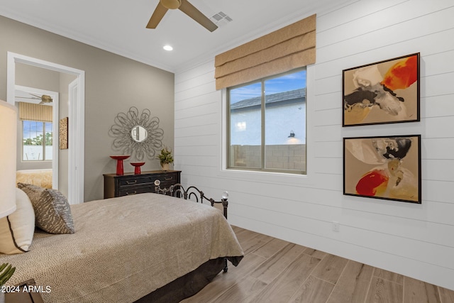 bedroom featuring crown molding, ceiling fan, and wood walls