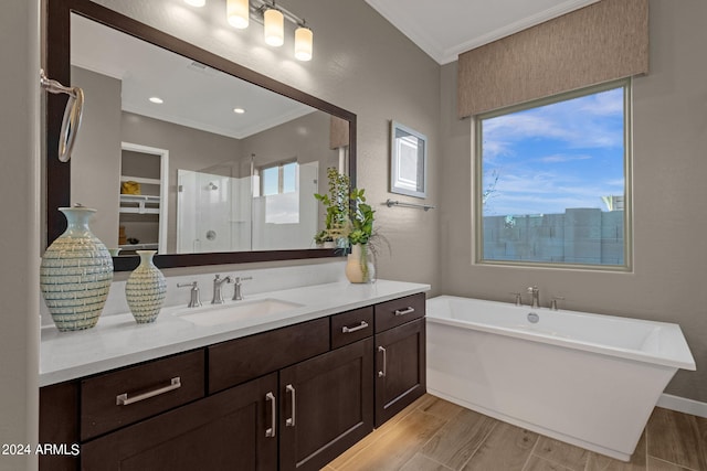 bathroom featuring a stall shower, a soaking tub, ornamental molding, wood finished floors, and vanity