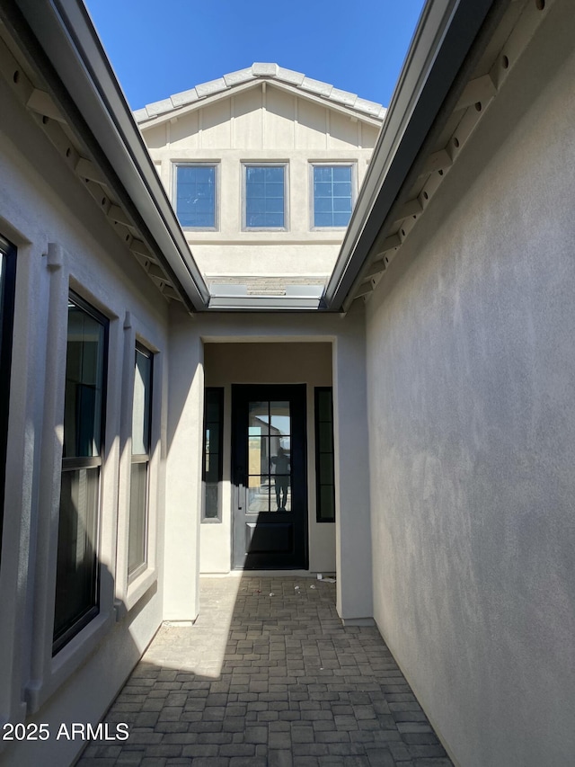 entrance to property featuring a patio and stucco siding