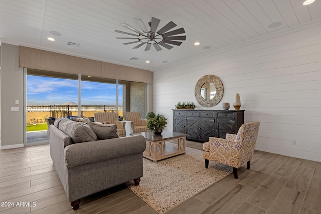 living area with ornamental molding, recessed lighting, visible vents, and light wood-style floors