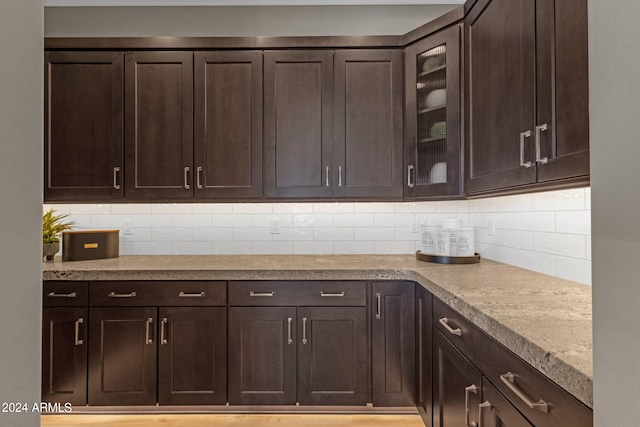 kitchen with glass insert cabinets and dark brown cabinetry