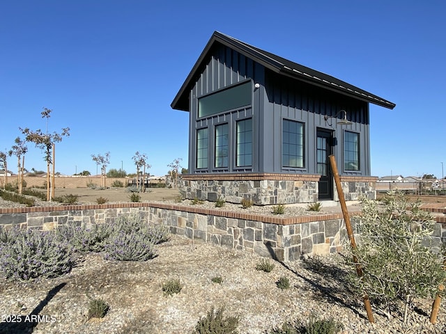 view of property exterior featuring stone siding and board and batten siding