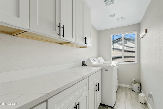 laundry room with visible vents, cabinet space, washer and clothes dryer, and baseboards