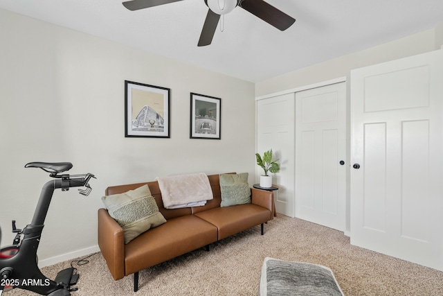 living area featuring a ceiling fan, light carpet, and baseboards