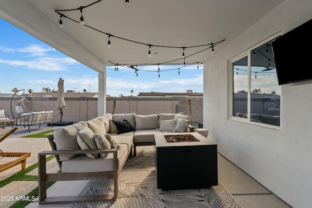 view of patio / terrace with an outdoor living space with a fire pit and fence