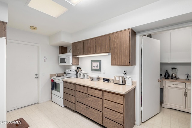 kitchen with light floors, white appliances, and light countertops