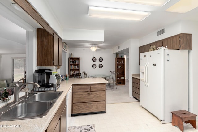 kitchen featuring visible vents, a ceiling fan, a sink, white appliances, and light countertops