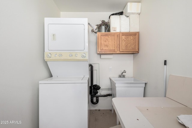 washroom with laundry area, stacked washer and dryer, and a sink