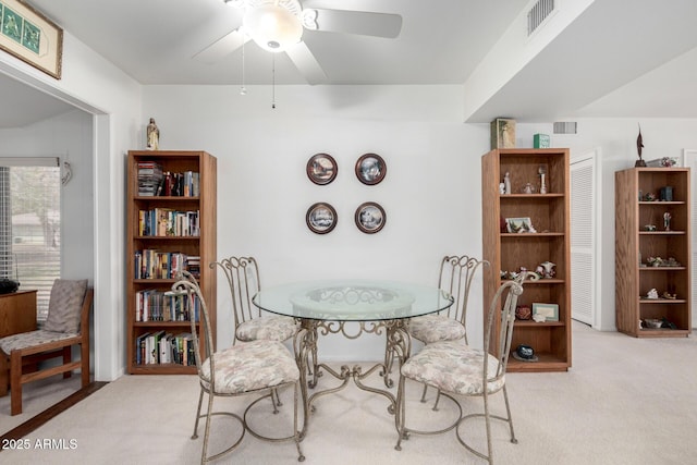 carpeted dining space featuring a ceiling fan and visible vents