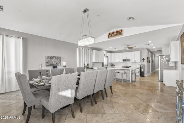 dining area with ceiling fan and vaulted ceiling