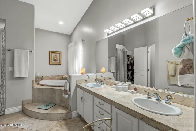 bathroom featuring vanity, tile patterned floors, and tiled tub