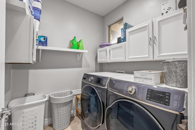 washroom featuring cabinets, light tile patterned floors, and washing machine and clothes dryer