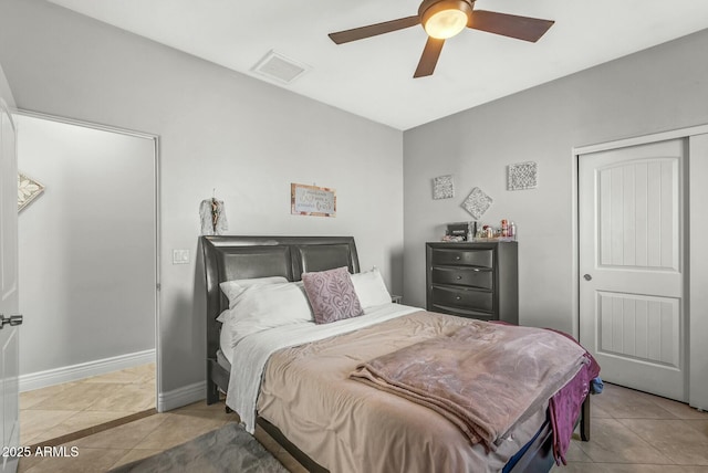 tiled bedroom featuring ceiling fan and a closet