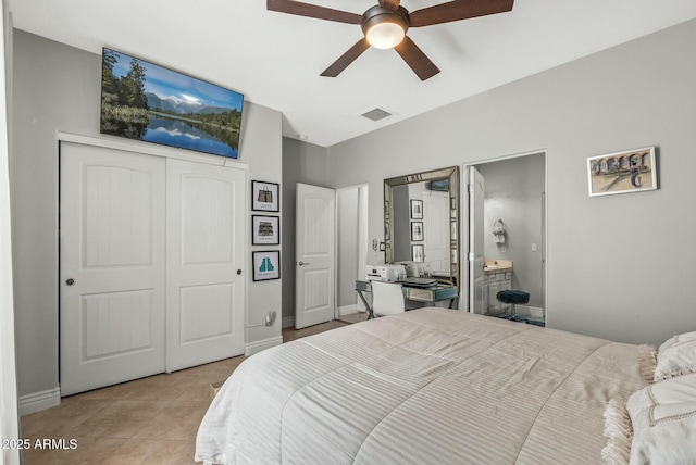 tiled bedroom with a closet, ensuite bathroom, and ceiling fan