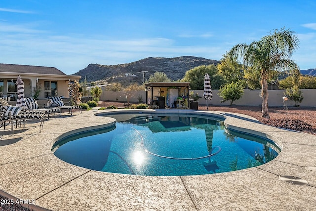 view of swimming pool with a mountain view and a patio area