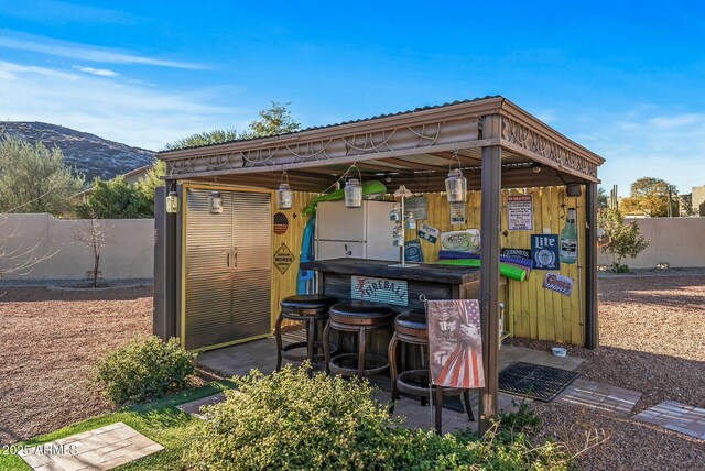 view of patio with a mountain view and a bar